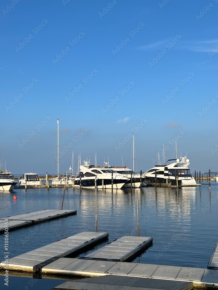 Fototapeta premium Skive yacht harbor in Skive, Denmark, Europe. Harbor with Wooden Pier and Sailing Ships. Beautiful view. Boats moored in Maarup Havn, Samsoe, Jutland, Denmark. Beauty in nature. Sailboats in harbor