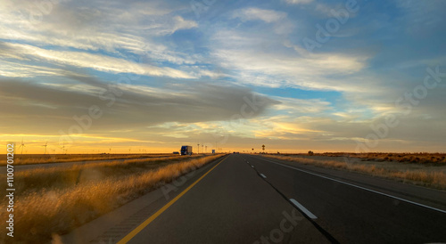 Beautiful road at Sunset on a road  with fields blue and saffron sky
