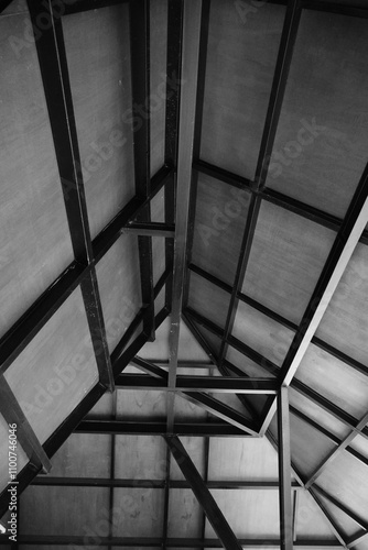 The roof of a building is made of wood with a black iron frame. photo