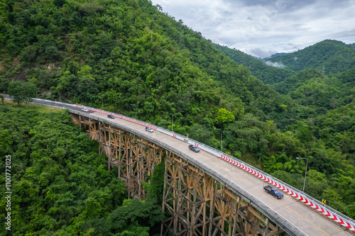 An aerial view of Phor Khun Pha Muang Bridge, or Huai Tong Bridge in Phetchabun, showcases its majestic span through a high mountain pass, connecting northern and northeastern Thailand