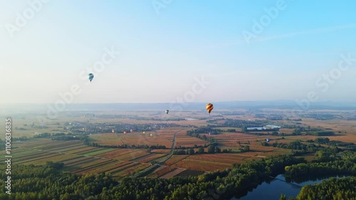 Stunning 4K aerial footage of a drone filming hot air balloons. Flying over farming fields and river. Filmed on a beautiful summer morning. Part of a hot air ballon festival in Prelog, Croatia. photo