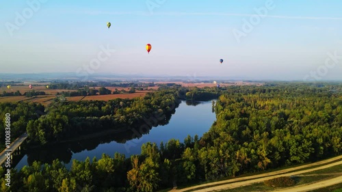 Stunning 4K aerial footage of a drone filming hot air balloons. Flying over farming fields and river. Filmed on a beautiful summer morning. Part of a hot air ballon festival in Prelog, Croatia. photo