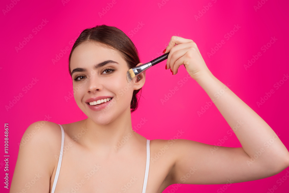 Fototapeta premium Woman applies powder on the face using makeup brush. Beautiful girl doing contouring apply blush on cheeks. Face beauty cosmetics. Fresh skin and natural make up. Powder blush on facial skin.