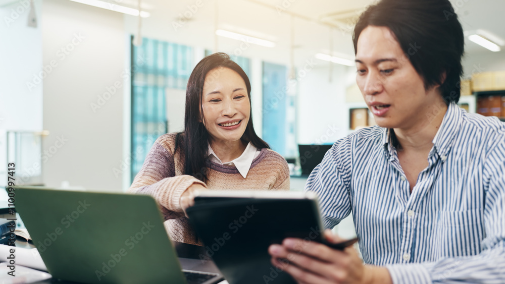 Japanese man, woman and tablet in coworking for collaboration, feedback and review on laptop. Business people, teamwork and technology in brainstorming, discussion or project management as colleagues Japanese man, woman and tablet in coworking for collaboration, feedback and review on laptop. Business people, teamwork and technology in brainstorming, discussion or project management as colleagues