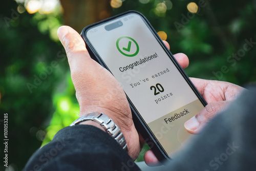 Man got a congratulatory message on his mobile phone earning points by shopping online. Modern marketing strategy loyalty program for customer engagement.