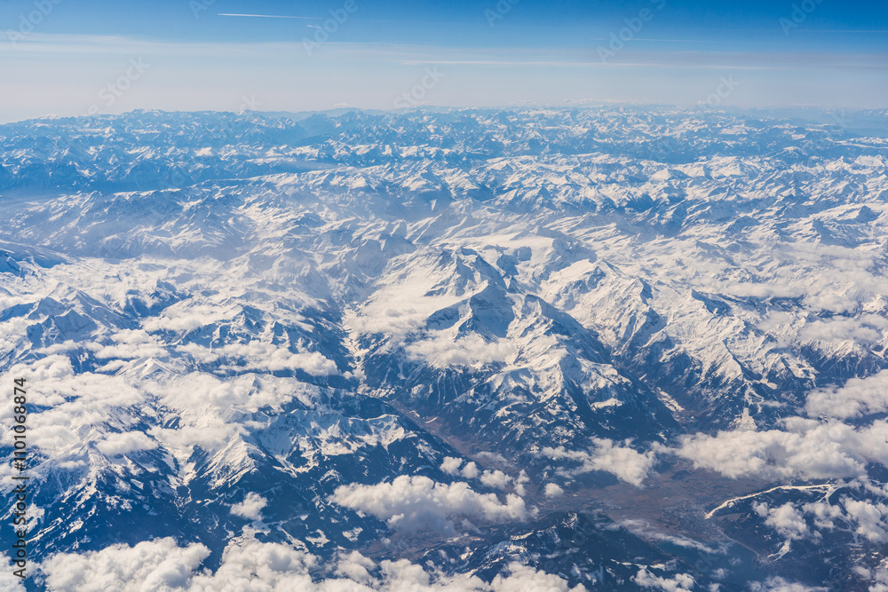 Fototapeta premium clouds and snow covered alp mountains from sky