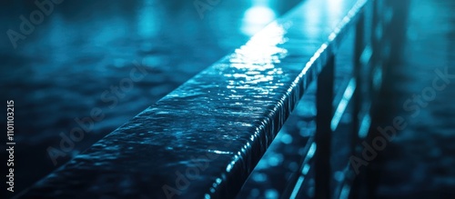 Close up of a boat handrail with geometric patterns reflecting water creating a design that emphasizes materiality and aesthetics at night photo