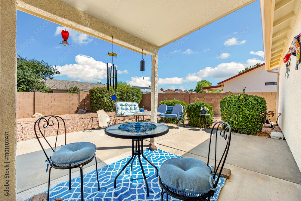 Fototapeta premium Outdoor patio with seating area under shade during sunny day in residential yard