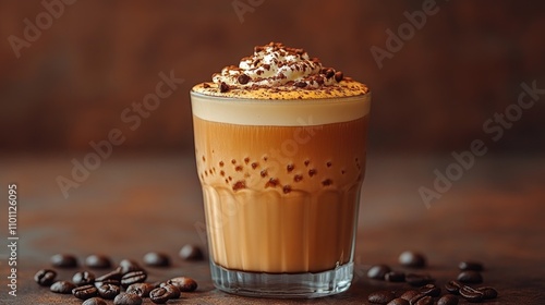 Delicious creamy coffee drink topped with whipped cream and chocolate flakes served in a transparent glass with coffee beans around it photo