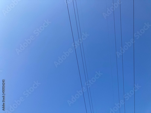 The sky was very clear and blue, with no clouds, and many black power lines were strung across the sky, the city concept