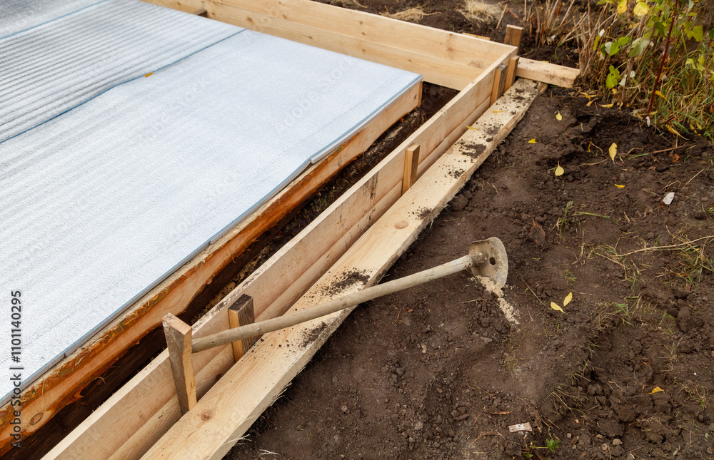 Obraz premium A wooden board is laying on the ground next to a concrete slab