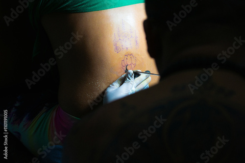 Photography Buddhist monk doing traditional Buddhist Thai Sak Yant tattoo
