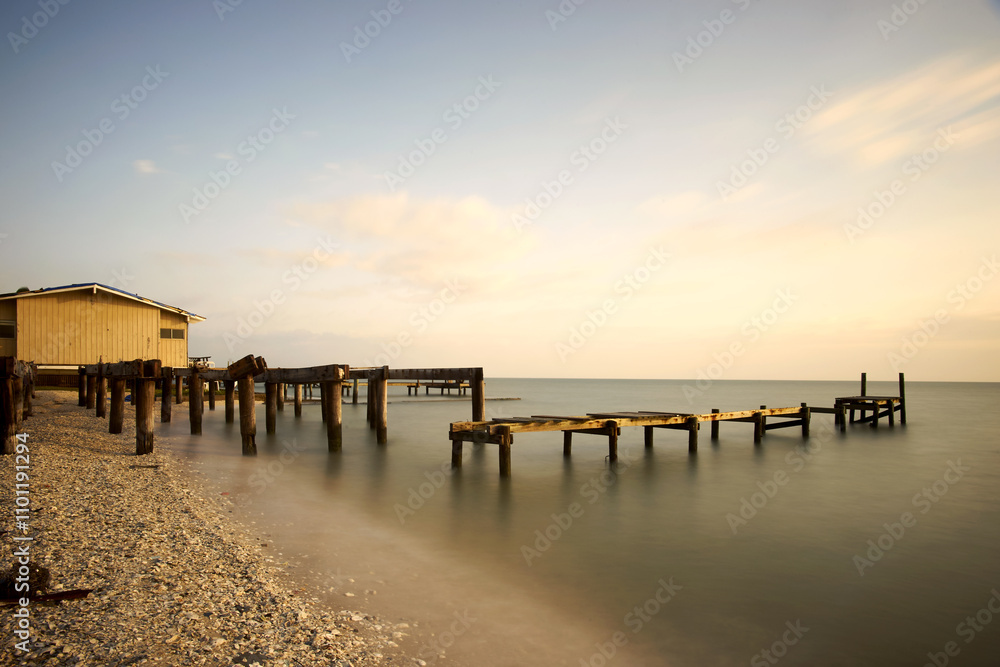 Fototapeta premium Golden hour casts a warm glow over the hurricane damaged wooden
