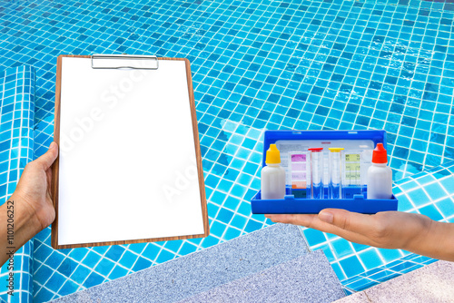 Water tester on wooden floor with clipboard in girl hand over clear swimming pool water background, quality water tester equipment photo