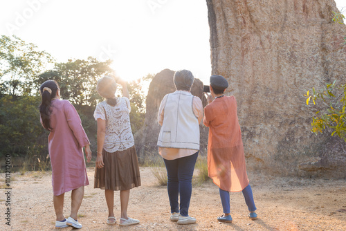 Group of Asian retirement women travelling, hiking, walking togehter in park, senior pensioner friends spend time exercise trekking in forest, unrecognizable elderly tourist lifestyle one day trip photo