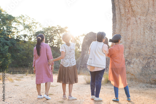 Group of Asian retirement women travelling, hiking, walking togehter in park, senior pensioner friends spend time exercise trekking in forest, unrecognizable elderly tourist lifestyle one day trip photo