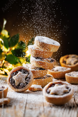 A close-up view of the Christmas mince pies sprinkled with icing sugar, focus on the middle. Traditional british Christmas dessert