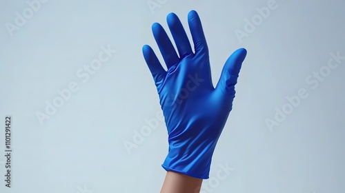 A hand wearing a blue nitrile glove, raised with fingers extended, against a white background.
