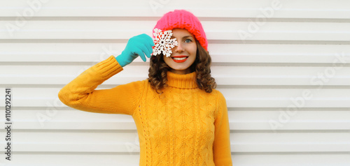 Happy smiling young woman with christmas snowflakes having fun in sweater, hat on white background photo