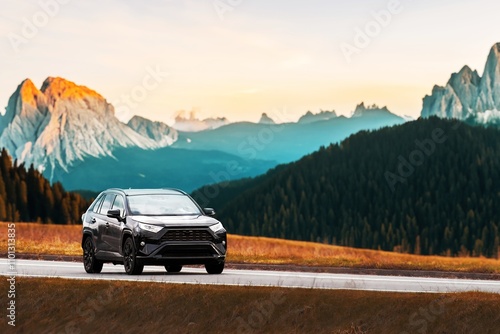 modern family SUV car journeys along a scenic road with majestic nature and a golden sunset in the backdrop. Subcompact truck with more offroad capabilities and 4WD