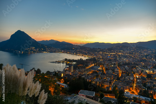 Obraz na płótnie sunset over lake lugano with the lights of the city turning on w salonie