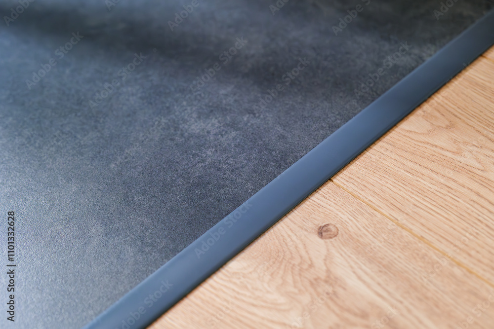 Anthracite expansion strip between ceramic tiles and floor panels. Aesthetic floor finishing. finishing strip. Interior