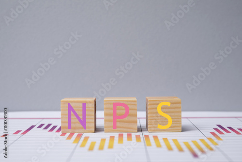 NPS (net promoter score) abbreviation made of cubes against grey background photo