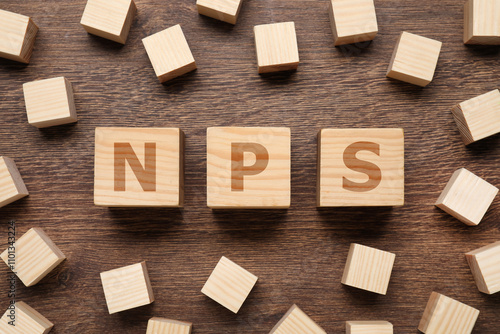 NPS (net promoter score) abbreviation made of cubes on wooden table, top view photo