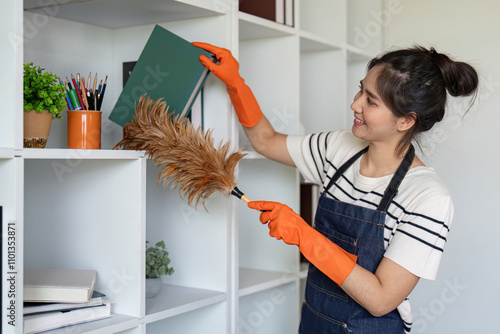 Woman dusting shelves with feather duster in office setting