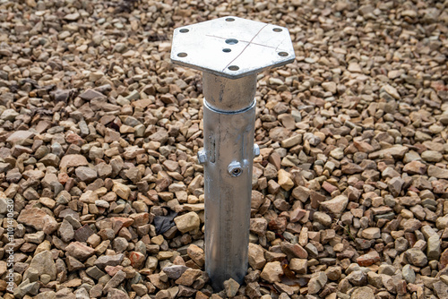 Galvanized screw piles screwed into the ground. Rubble at the construction site