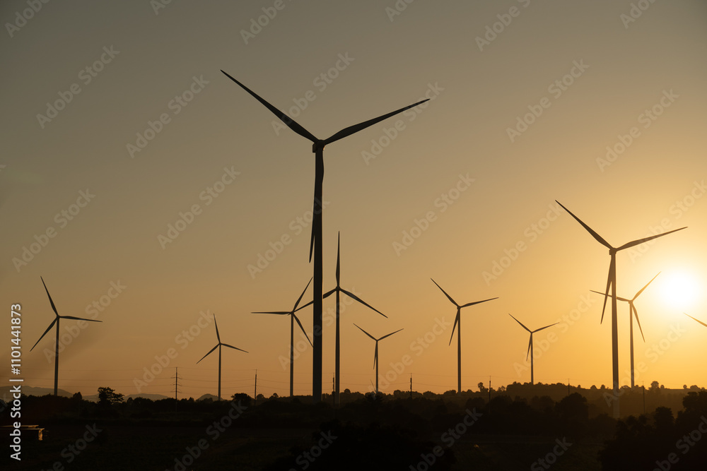 Fototapeta premium Windmills for electric power production, summer field, renewable energy sunset.