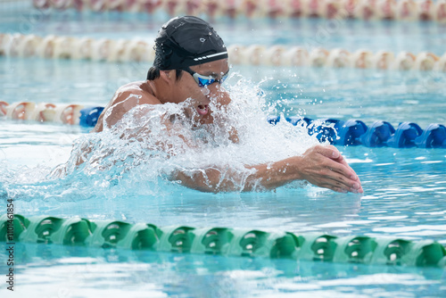 Close-up side view of a man swimming breaststroke in a swimming pool