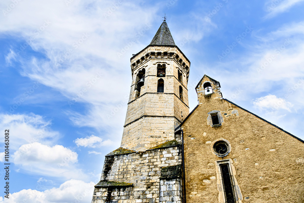Fototapeta premium Church of San Miguel in Romanesque-Gothic style, in Viella, Valle de Aran, Catalonia, Spain, under a blue sky with white clouds