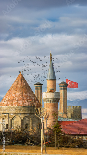 Erzurum Twin Minaret Madrasa with Turkish flag and tiled brick minarets photo