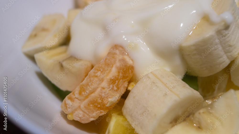 Banana, kiwi, mandarin sliced in a deep plate. Fruit salad with yogurt Banana, kiwi, mandarin sliced in a deep plate. Fruit salad with yogurt