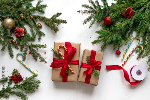 Christmas gifts in craft paper and tied with a red ribbon. Christmas gift wrapping using eco-friendly materials and pine branches