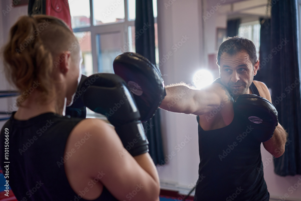 Fototapeta premium Kickboxer hitting the pads with his coach