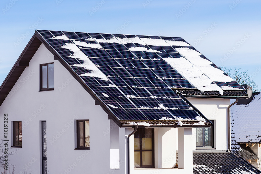 Fototapeta premium Winter Solar Panels on House Roof with Melting Snow Covered. Efficiency of Solar Energy Station in Snow Winter. 