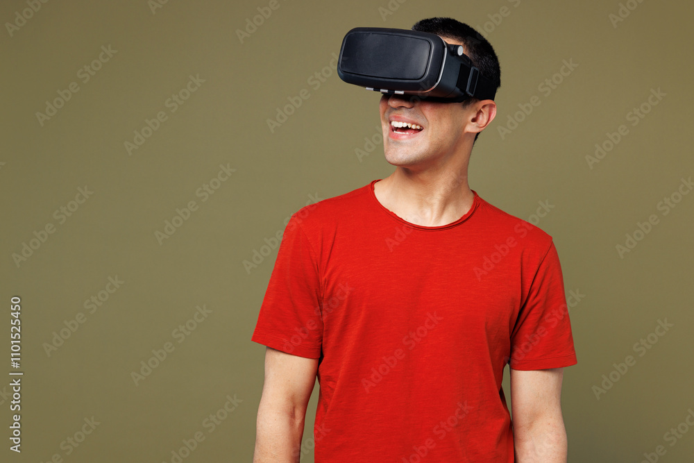 Young smiling happy cheerful cool middle eastern man he wear red t-shirt casual clothes watching in vr headset pc gadget isolated on plain pastel green background studio portrait. Lifestyle concept. Young smiling happy cheerful cool middle eastern man he wear red t-shirt casual clothes watching in vr headset pc gadget isolated on plain pastel green background studio portrait. Lifestyle concept.