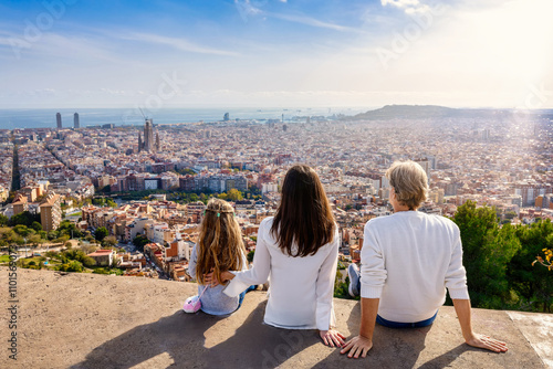 A family enjoys the panoramic view of the skyline of Barcelona, Spain, during their city trip vacation