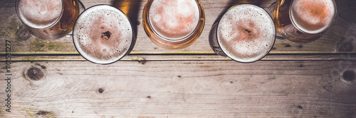 Glasses of beer on an old wooden table. Top view