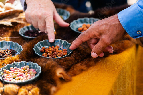Aboriginal mans hand pointing to bush tucker and seeds displayed at event