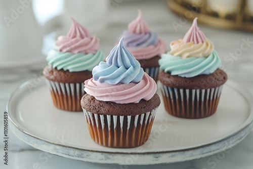 Four chocolate cupcakes with colorful frosting