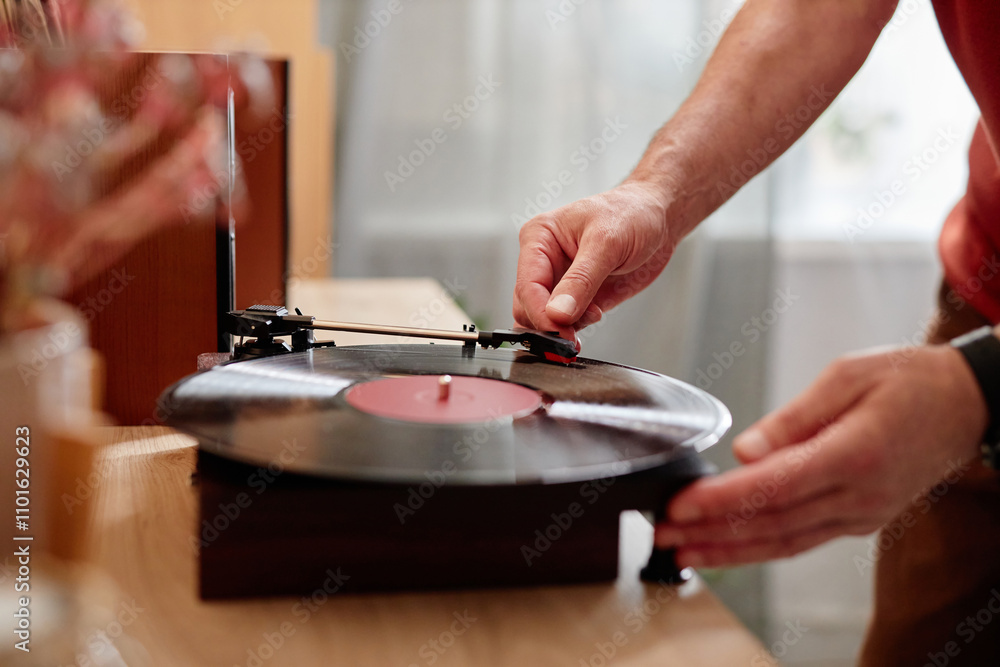 Side view closeup of unrecognizable senior man carefully setting up retro record player at home and listening to music copy space Side view closeup of unrecognizable senior man carefully setting up retro record player at home and listening to music copy space