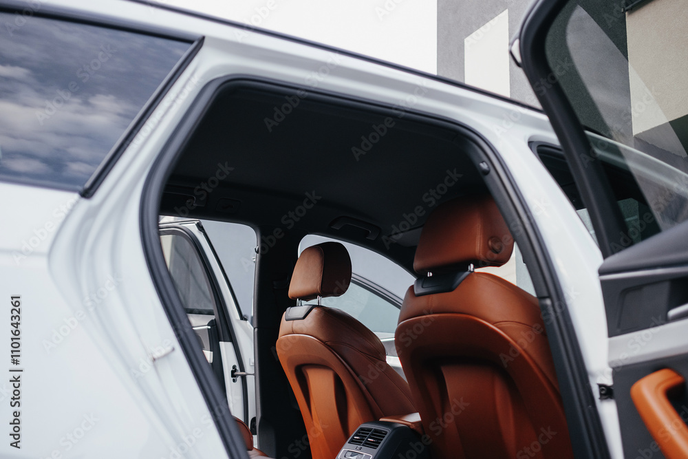 Fototapeta premium Modern brown car interior, leather steering wheel, climate control, navigation, air ducts, deflectors on the car panel, interior details.