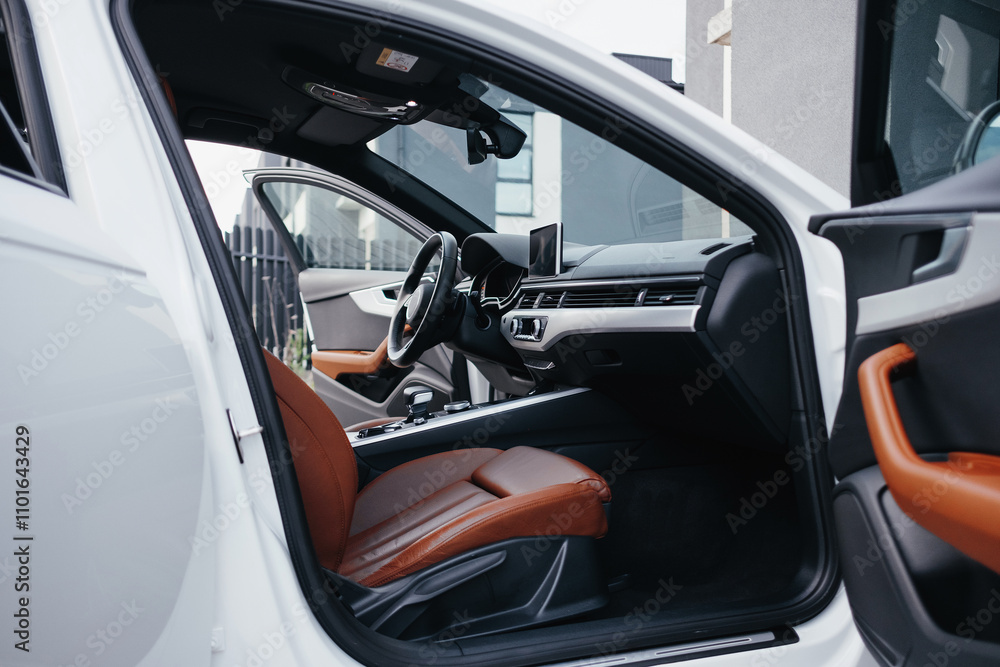Modern brown car interior, leather steering wheel, climate control, navigation, air ducts, deflectors on the car panel, interior details. Modern brown car interior, leather steering wheel, climate control, navigation, air ducts, deflectors on the car panel, interior details.