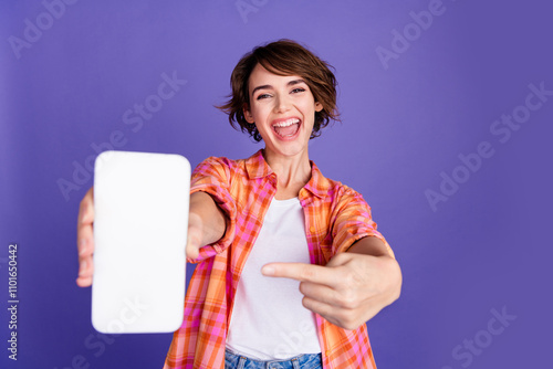 Portrait of nice young lady point finger empty space display wear shirt isolated on purple color background photo