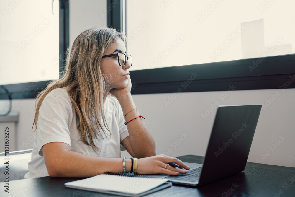 Portrait of serious millennial caucasian female student sit at desk at home study online on laptop. Thoughtful young attractive woman use computer take distant course or training. Education concept.. Portrait of serious millennial caucasian female student sit at desk at home study online on laptop. Thoughtful young attractive woman use computer take distant course or training. Education concept..