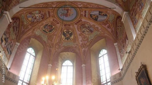 Wallpaper Mural Intricate painted ceiling in historic church with heraldic symbols, detailed artwork, and tall arched windows. Torontodigital.ca