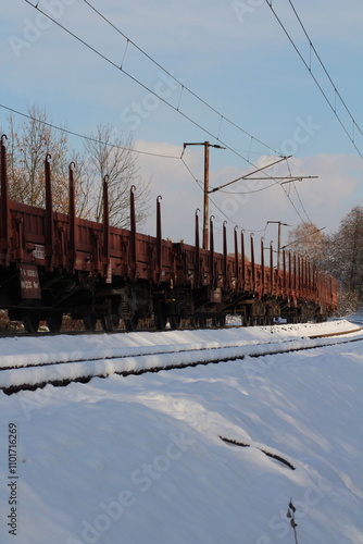 Cargo train on rails in winter with snow